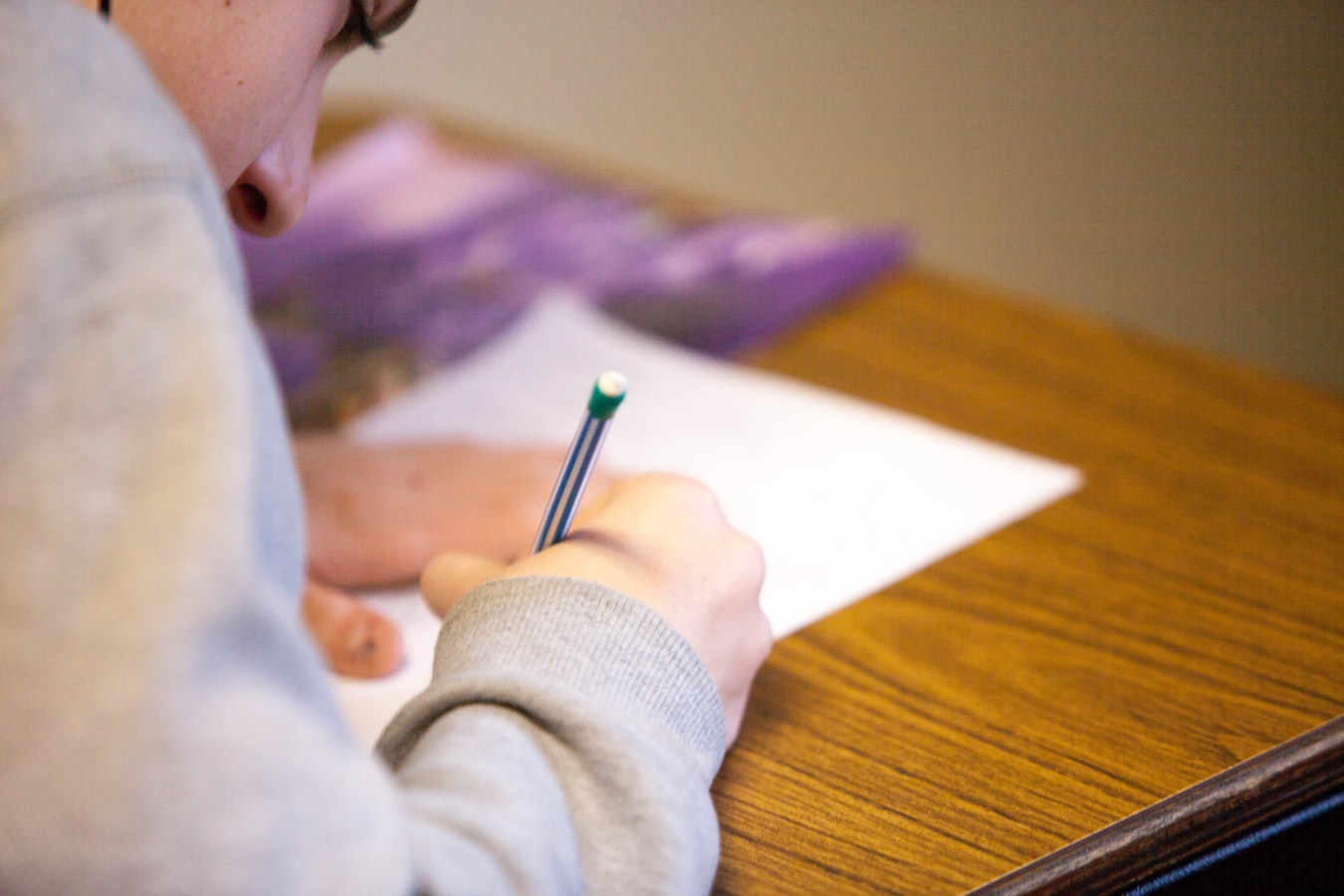 Un écolier en train d'écrire sur sa copie