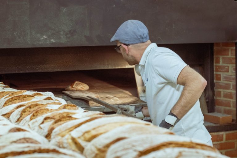 Un boulanger mettant du pain au four.