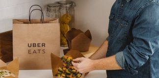 Un jeune homme dégustant un plat à emporter d'Uber Eats.