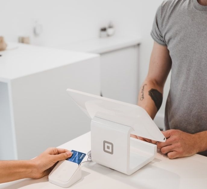 Une personne effectuant un paiement en magasin à l'aide de sa carte bancaire.