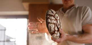 Un boulanger avec du pain en main.